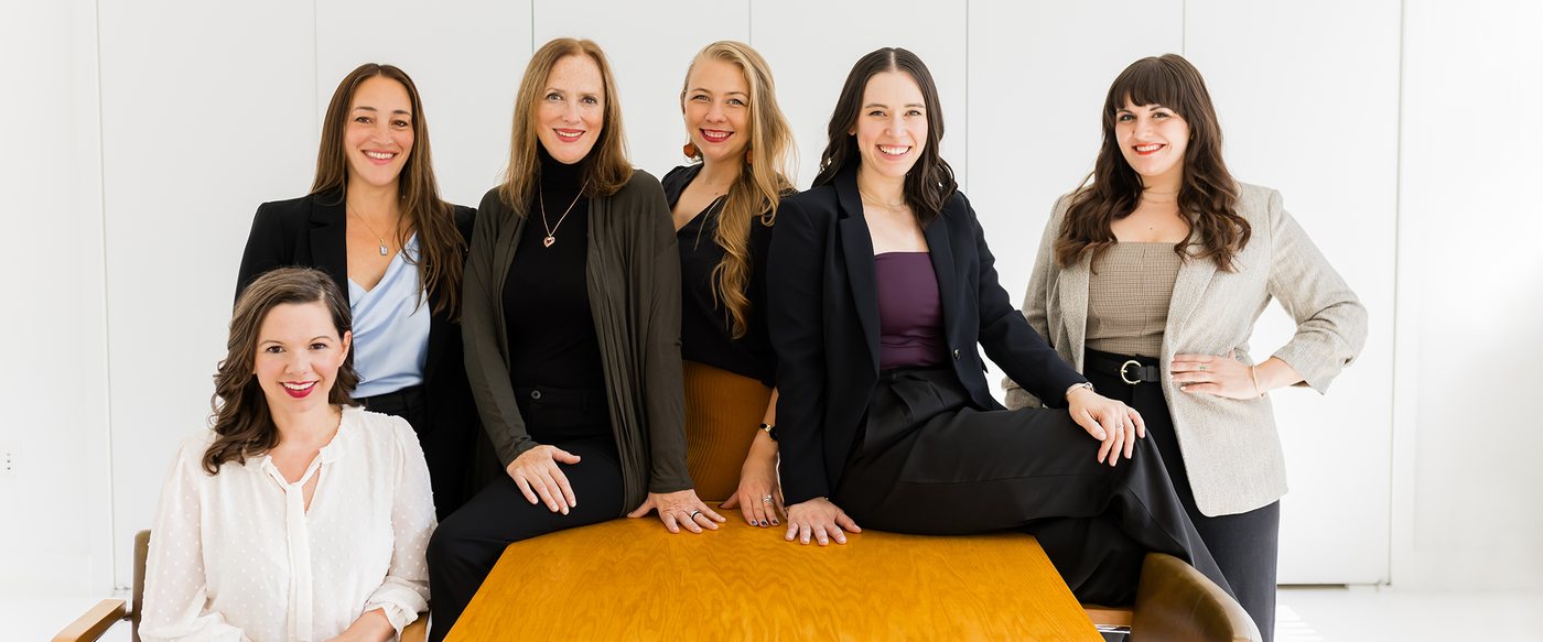 The Lisa Clampitt Matchmaking team seated together in conversation around a table in their New York office