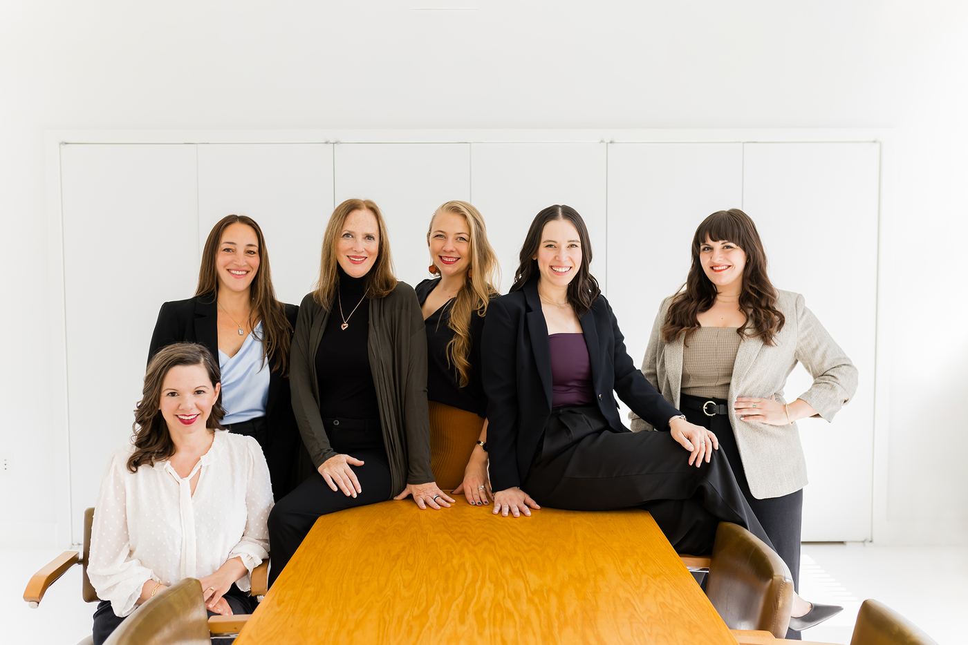 The Lisa Clampitt Matchmaking team seated together in conversation around a table in their New York office